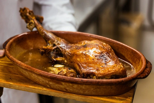 A slow-roasted leg of lamb in a clay dish at El Gamonal