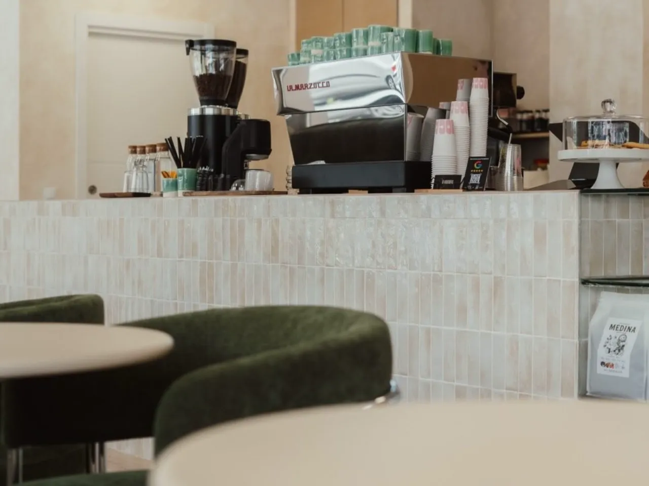 The bar at MOCA with the La Marzocco machine and green velvet chairs