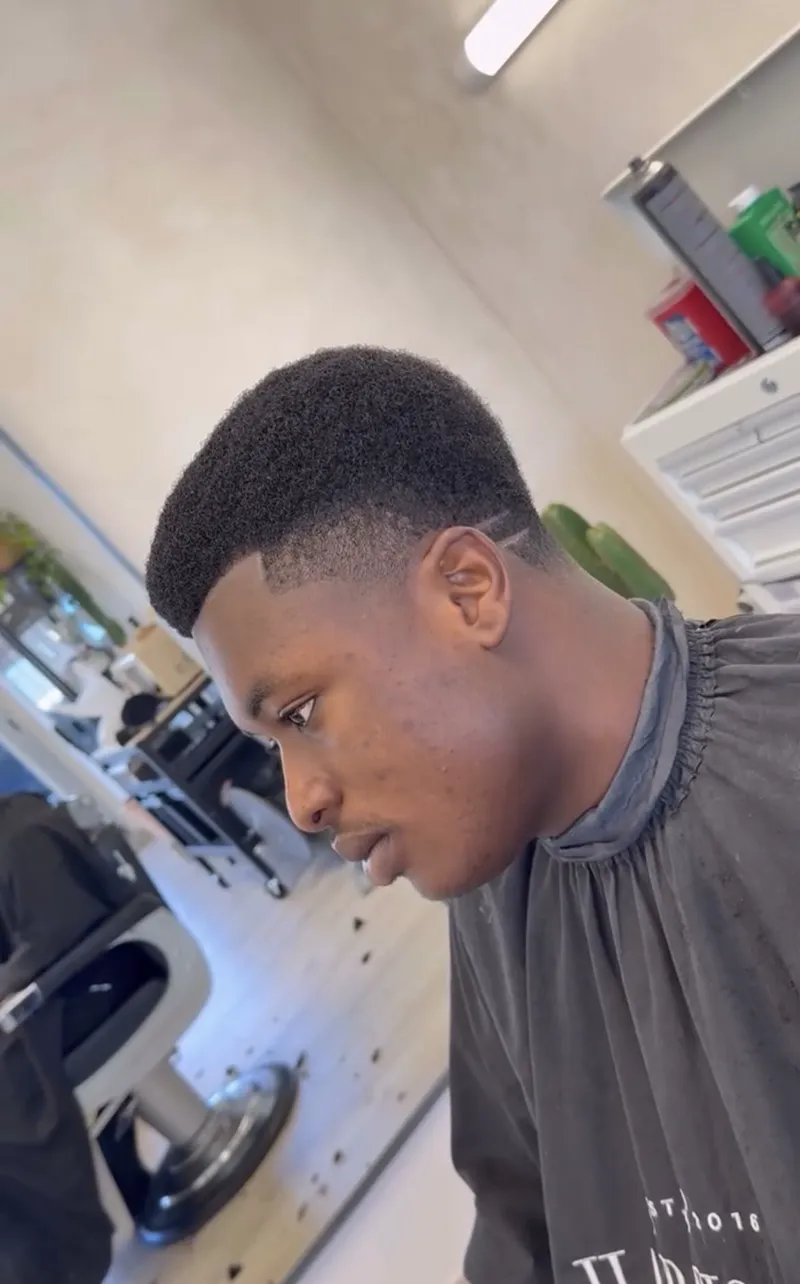 Afro taper with a razor hard part at Harrisons